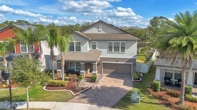 view of front of home with a porch, a garage, and a front yard