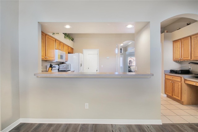 kitchen featuring white appliances and kitchen peninsula