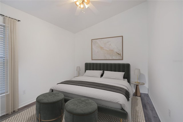 bedroom with multiple windows, ceiling fan, vaulted ceiling, and dark hardwood / wood-style flooring