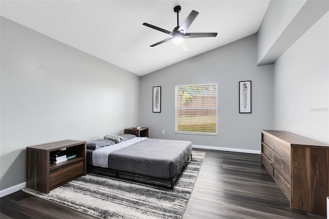 bedroom featuring ceiling fan, dark hardwood / wood-style floors, vaulted ceiling, and a textured ceiling