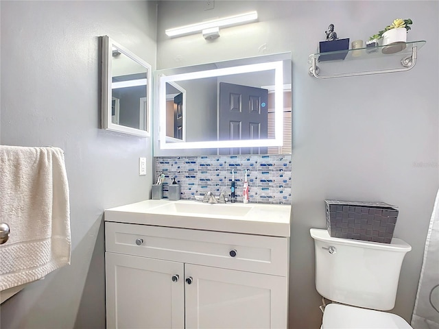 bathroom with vanity, decorative backsplash, and toilet