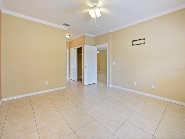 spare room featuring crown molding, ceiling fan, and light tile patterned floors