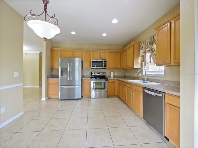 kitchen with appliances with stainless steel finishes, sink, pendant lighting, and light tile patterned floors