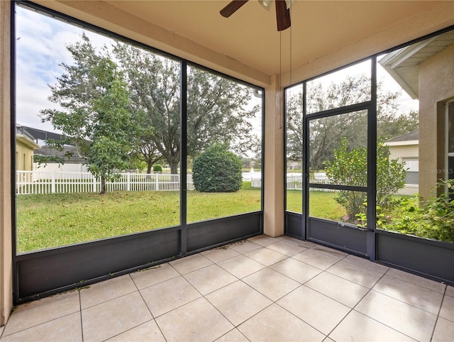 unfurnished sunroom featuring ceiling fan