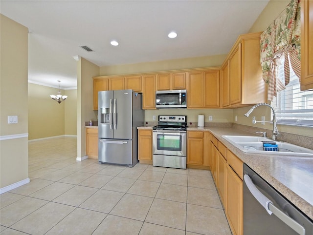 kitchen with hanging light fixtures, appliances with stainless steel finishes, sink, and light tile patterned floors