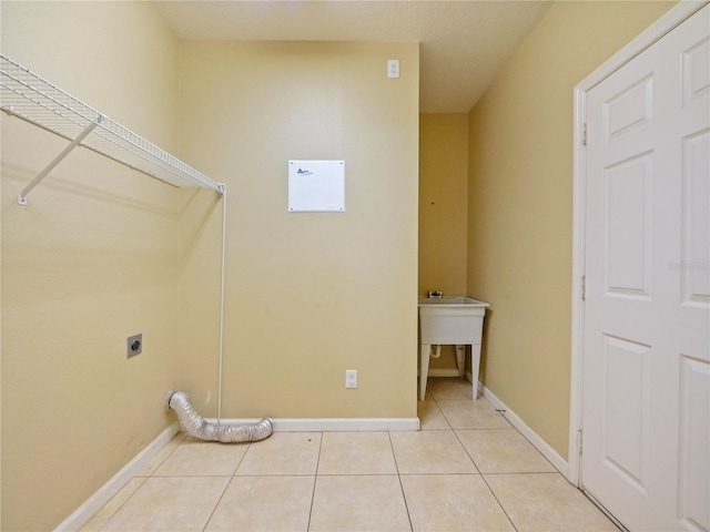 washroom with hookup for an electric dryer and light tile patterned floors