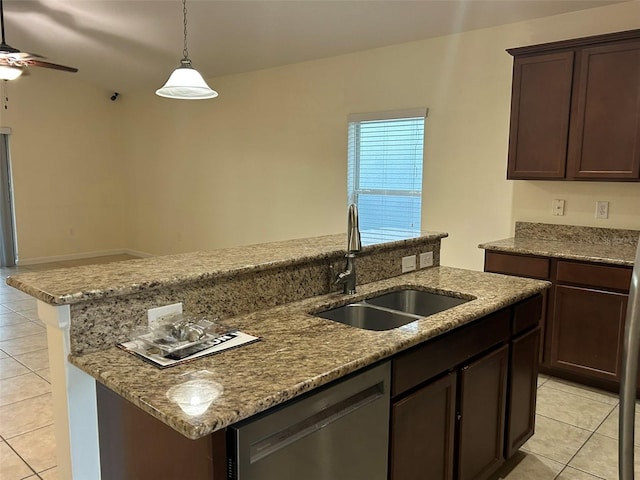 kitchen featuring dishwasher, sink, hanging light fixtures, a kitchen island with sink, and light stone counters