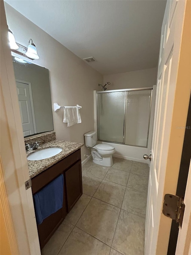 full bathroom with vanity, tile patterned floors, shower / bath combination with glass door, and toilet