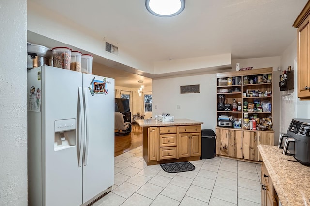 kitchen with white refrigerator with ice dispenser, kitchen peninsula, and light tile patterned flooring