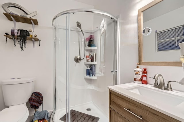 bathroom with walk in shower, vanity, and toilet