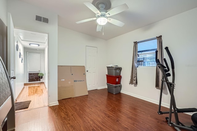 workout room with dark wood-type flooring and ceiling fan