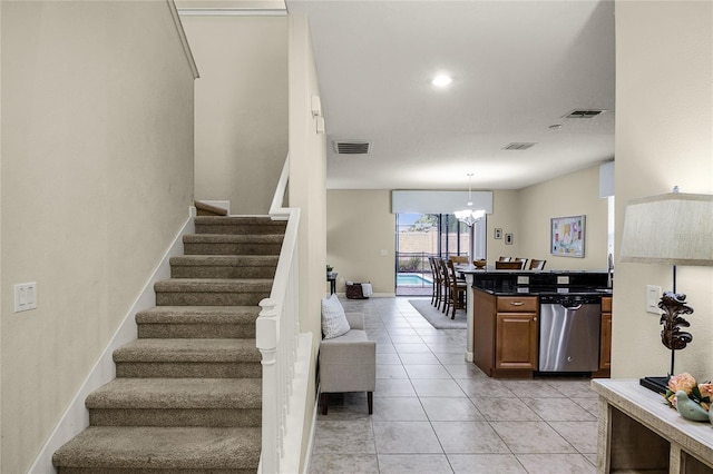 stairway featuring an inviting chandelier and tile patterned floors