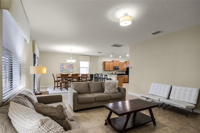 living room with light tile patterned floors and an inviting chandelier