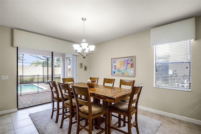 tiled dining room featuring an inviting chandelier