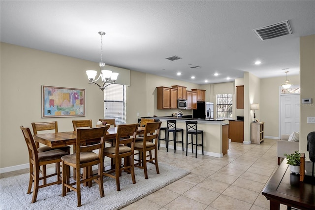 dining room with light tile patterned floors and an inviting chandelier