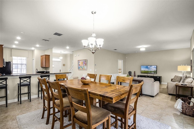 dining area featuring a chandelier and light tile patterned flooring