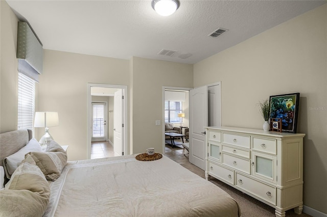 bedroom featuring light tile patterned flooring and a textured ceiling