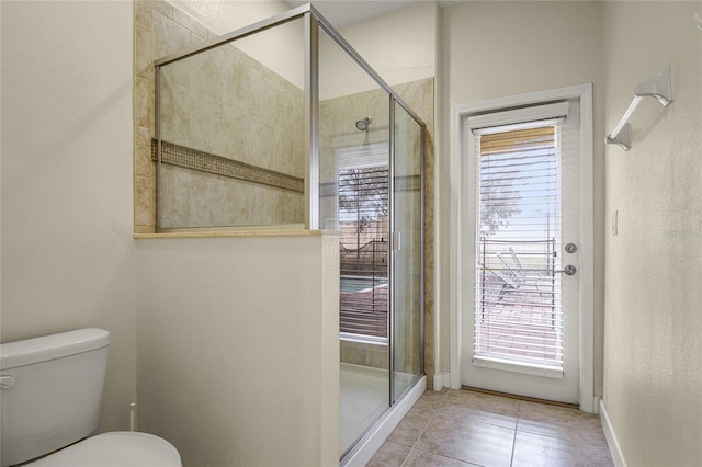 bathroom featuring a healthy amount of sunlight, toilet, and walk in shower