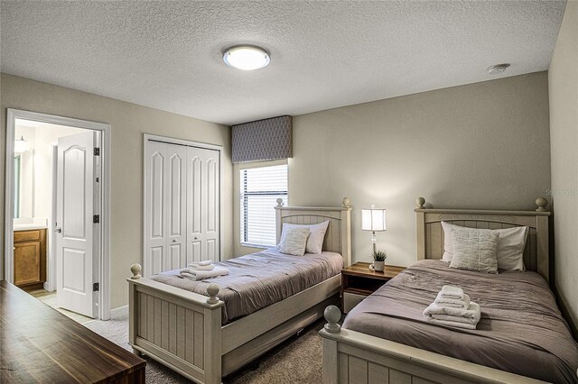 bedroom with a closet, light carpet, and a textured ceiling