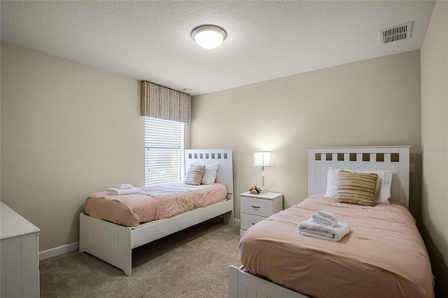 bedroom with light colored carpet and a textured ceiling