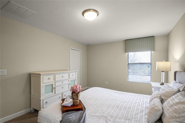 carpeted bedroom with a textured ceiling