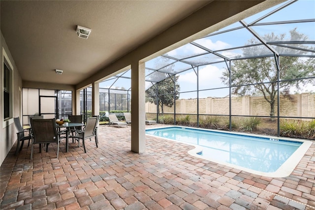 view of pool with a patio and glass enclosure