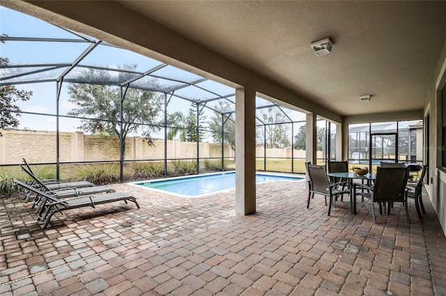 view of swimming pool featuring a patio area and glass enclosure