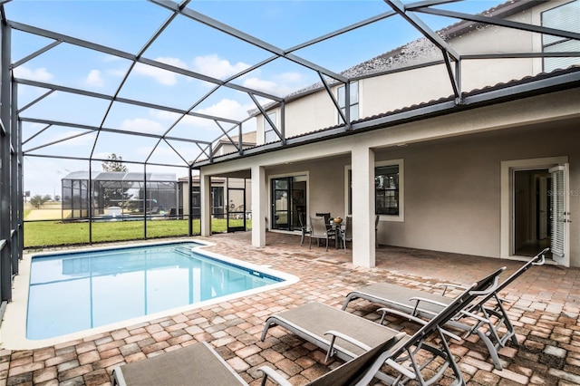 view of swimming pool with a patio and glass enclosure