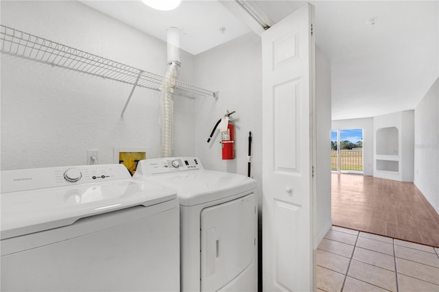 laundry area featuring light tile patterned floors and washing machine and clothes dryer