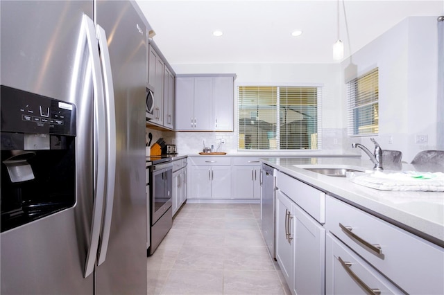 kitchen featuring sink, plenty of natural light, hanging light fixtures, and appliances with stainless steel finishes