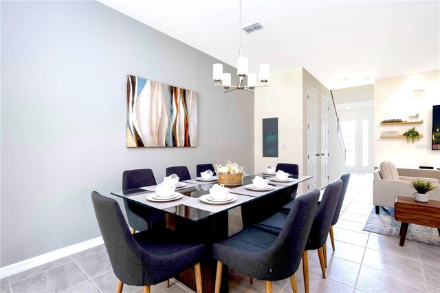 tiled dining room featuring a chandelier and electric panel