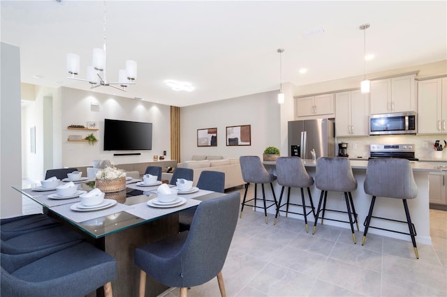 dining area with light tile patterned floors and an inviting chandelier