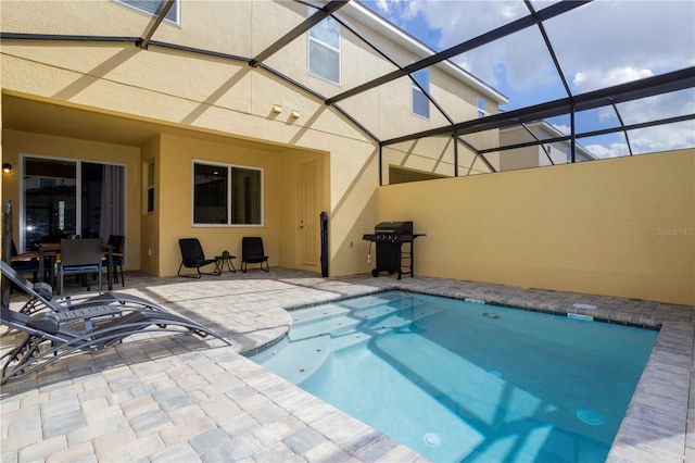 view of swimming pool featuring a lanai, area for grilling, and a patio area