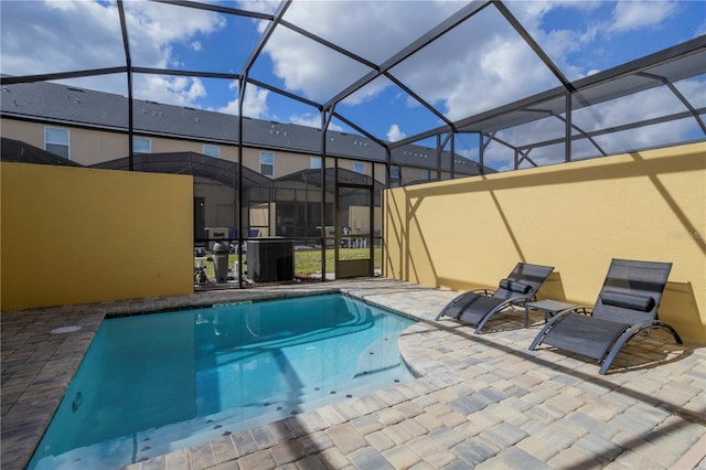 view of swimming pool with a lanai, a patio area, and central air condition unit