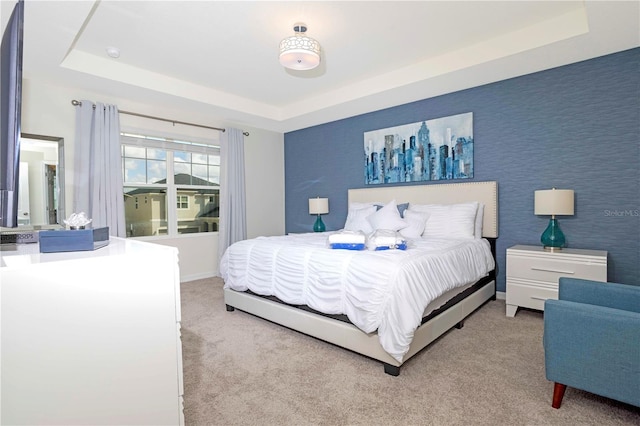 bedroom featuring a raised ceiling and carpet flooring