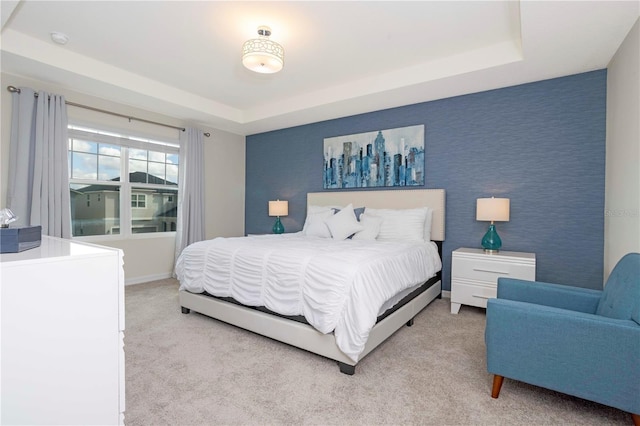 carpeted bedroom with a tray ceiling