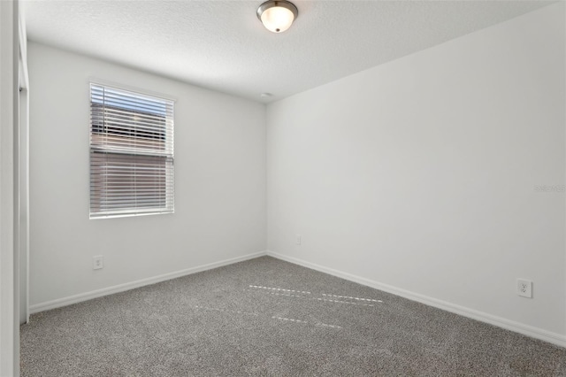 unfurnished room featuring carpet floors and a textured ceiling