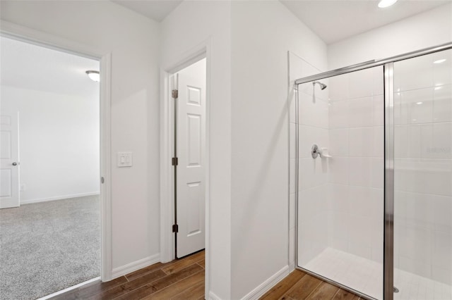 bathroom with hardwood / wood-style flooring and an enclosed shower