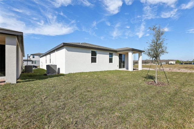 back of house with a yard and central AC