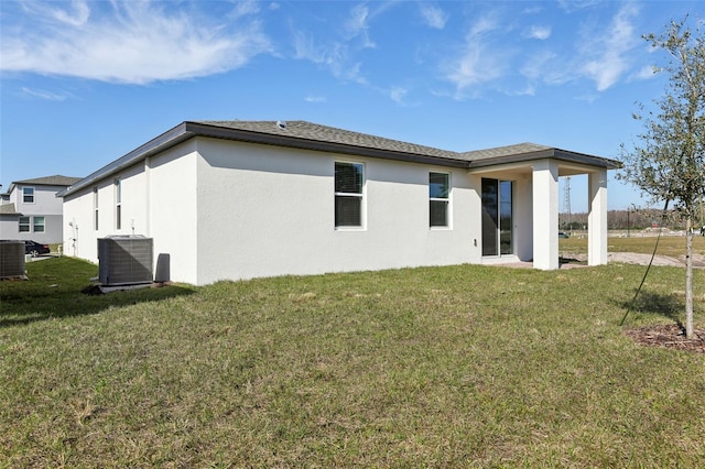 back of property featuring a yard and central air condition unit