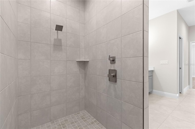 bathroom featuring vanity, a tile shower, and tile patterned floors