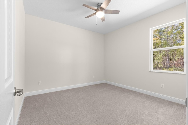 carpeted spare room with ceiling fan