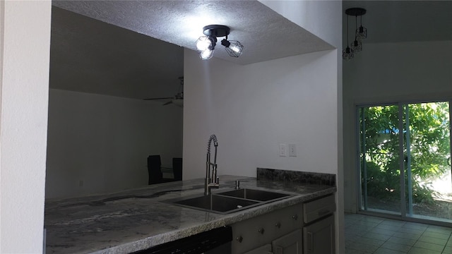 kitchen with sink, stone countertops, a textured ceiling, light tile patterned floors, and ceiling fan with notable chandelier