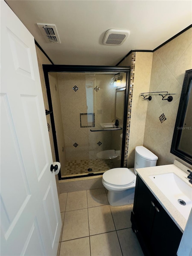 bathroom featuring walk in shower, tile patterned floors, toilet, tile walls, and vanity