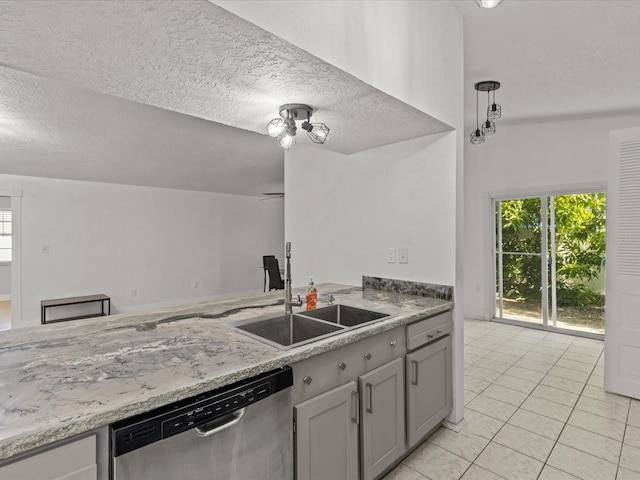 kitchen with sink, light tile patterned floors, gray cabinets, a textured ceiling, and stainless steel dishwasher