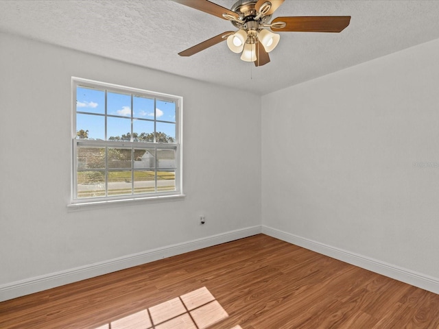 spare room with ceiling fan, hardwood / wood-style flooring, and a textured ceiling