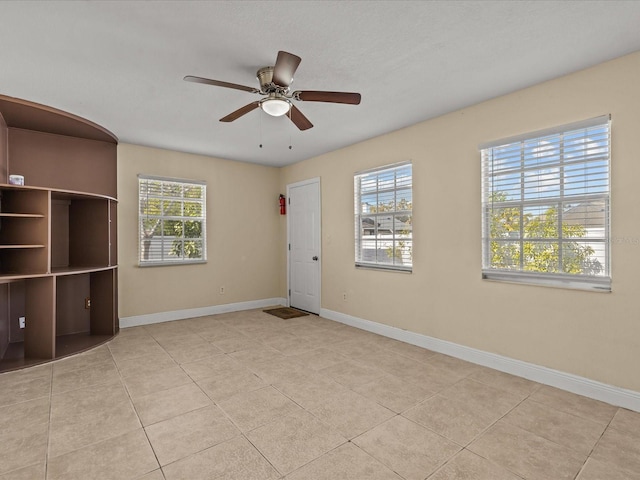 tiled spare room with ceiling fan