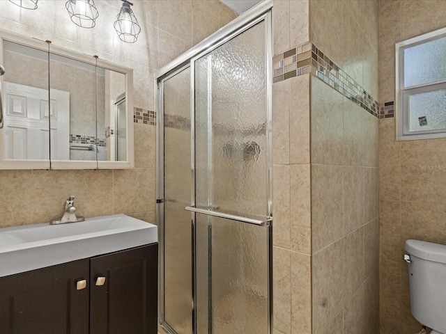 bathroom with a shower with door, tile walls, vanity, tasteful backsplash, and toilet