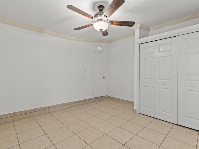 unfurnished bedroom featuring ceiling fan, ornamental molding, a closet, and light tile patterned floors