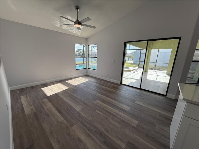 spare room with dark wood-type flooring, ceiling fan, and vaulted ceiling